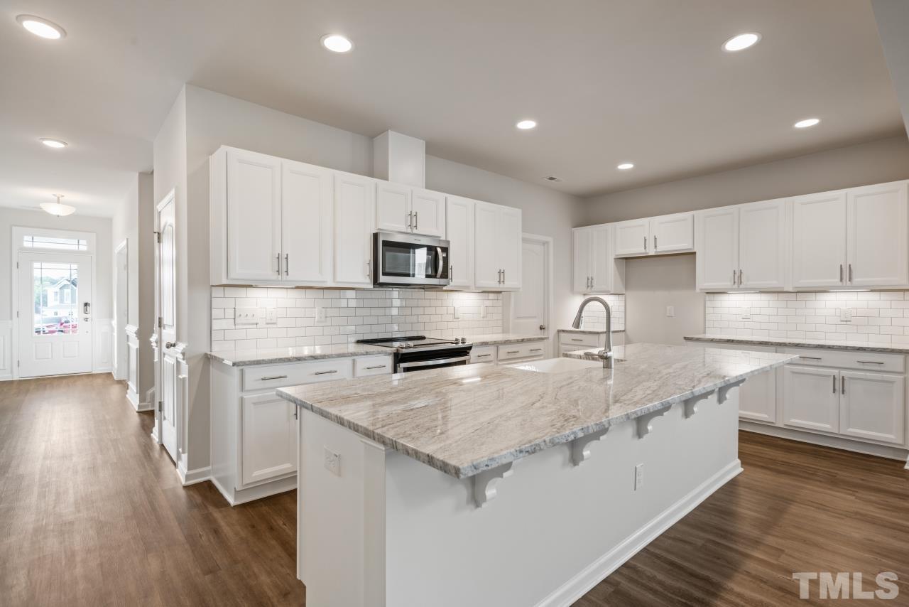 201 Karlov Road Garner, NC 27529 - Photo 5 of 39 a kitchen with a sink a stove a refrigerator and cabinets