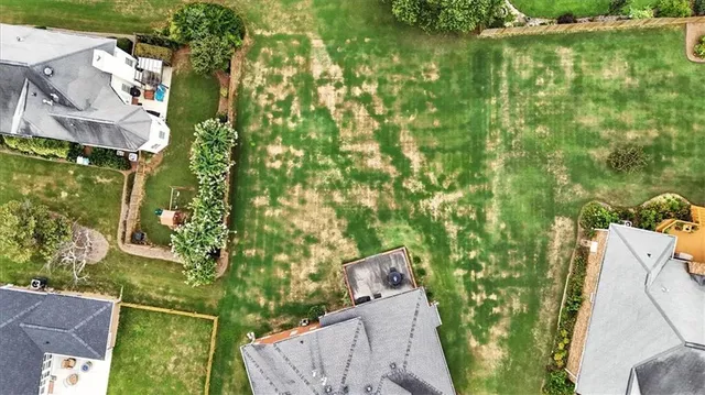 an aerial view of residential houses with outdoor space and trees