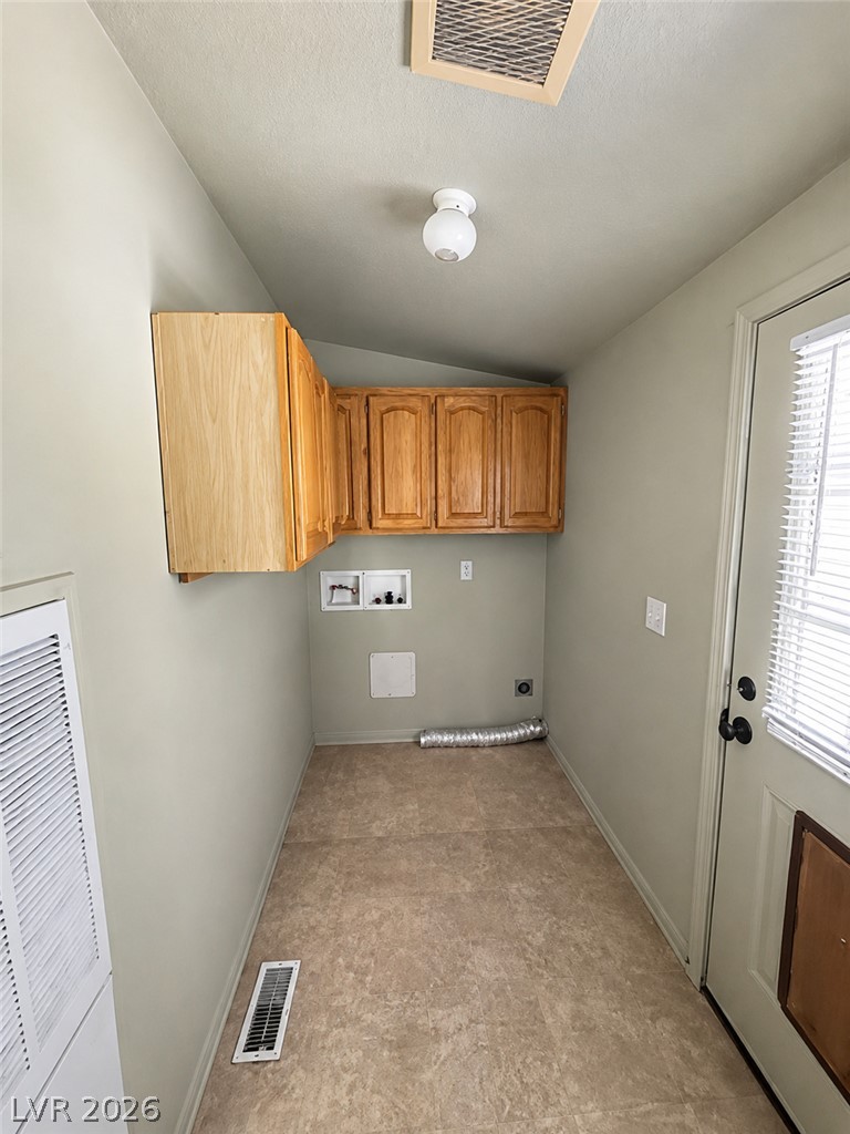 5561 Doubletree Road Pahrump, NV 89061 - Photo 13 of 19 Functional utility space features overhead wood cabinetry and tile flooring.