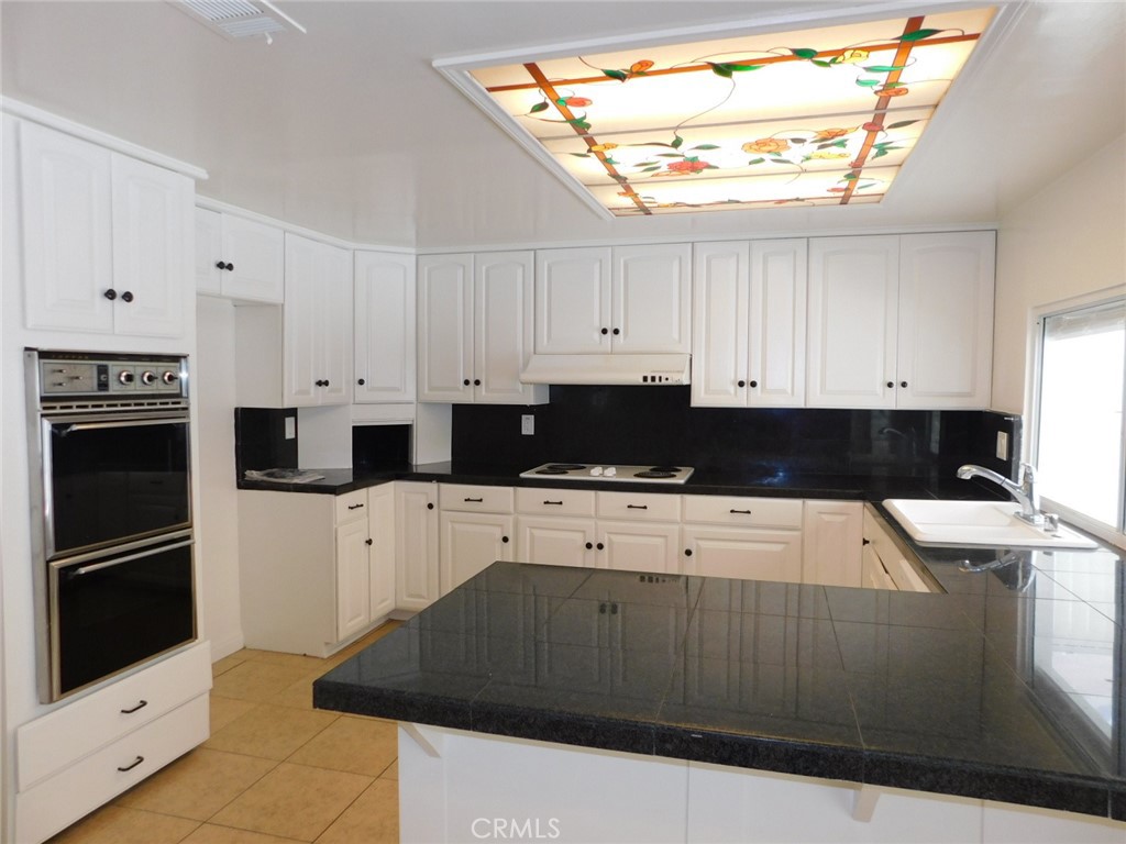 2618 Athena Place Fullerton, CA 92833 - Photo 12 of 27 a kitchen with a refrigerator and white cabinets