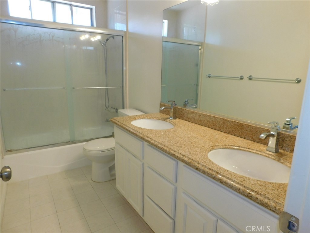 2618 Athena Place Fullerton, CA 92833 - Photo 24 of 27 a bathroom with a granite countertop sink a toilet and shower