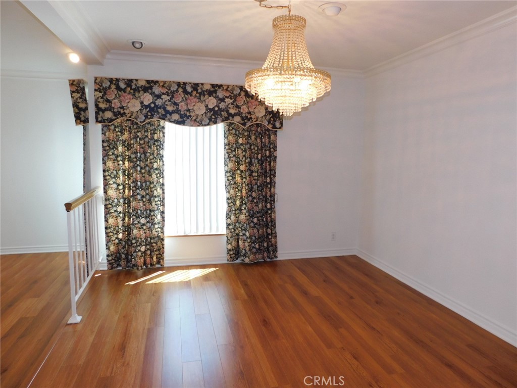 2618 Athena Place Fullerton, CA 92833 - Photo 6 of 27 a view of a hallway with wooden floor and a chandelier