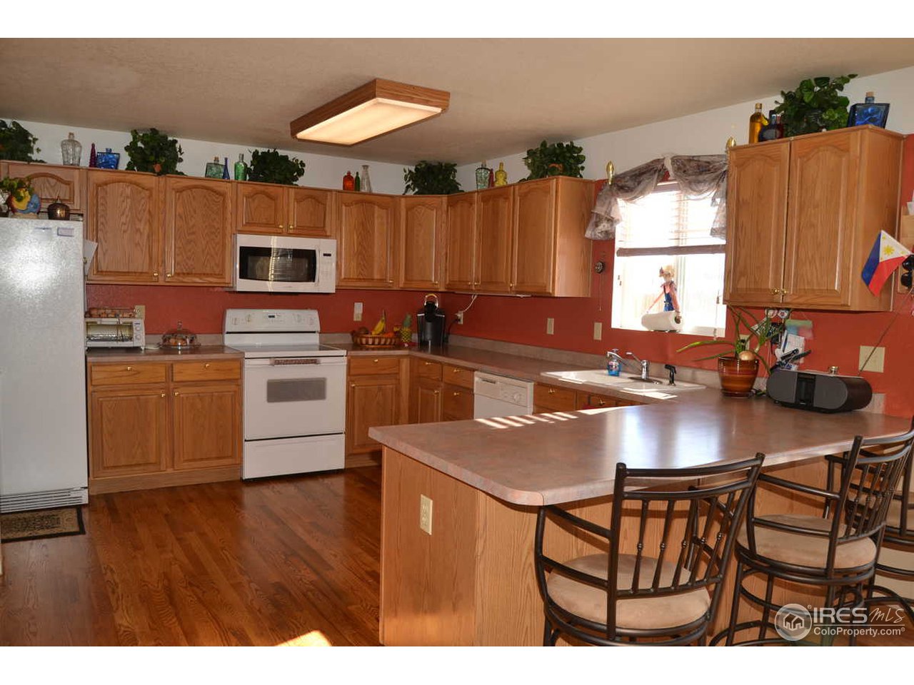 1321 Trail Ridge Road Longmont, CO 80504 - Photo 8 of 25 a kitchen with stainless steel appliances granite countertop a sink a microwave a refrigerator and white cabinets