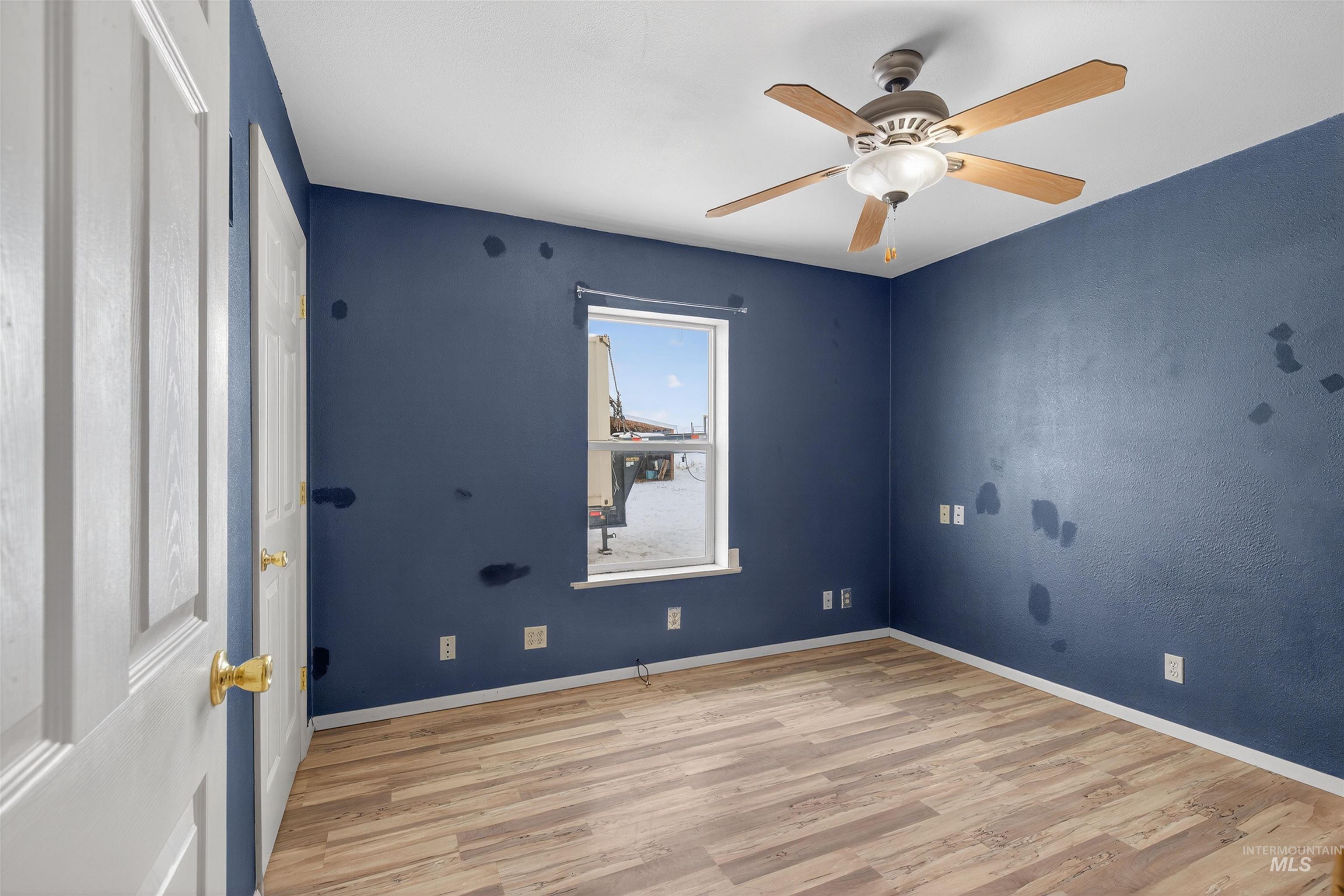 1585 Woodside Road Winchester, ID 83555 - Photo 11 of 47 Unfurnished room featuring light wood-type flooring and a ceiling fan