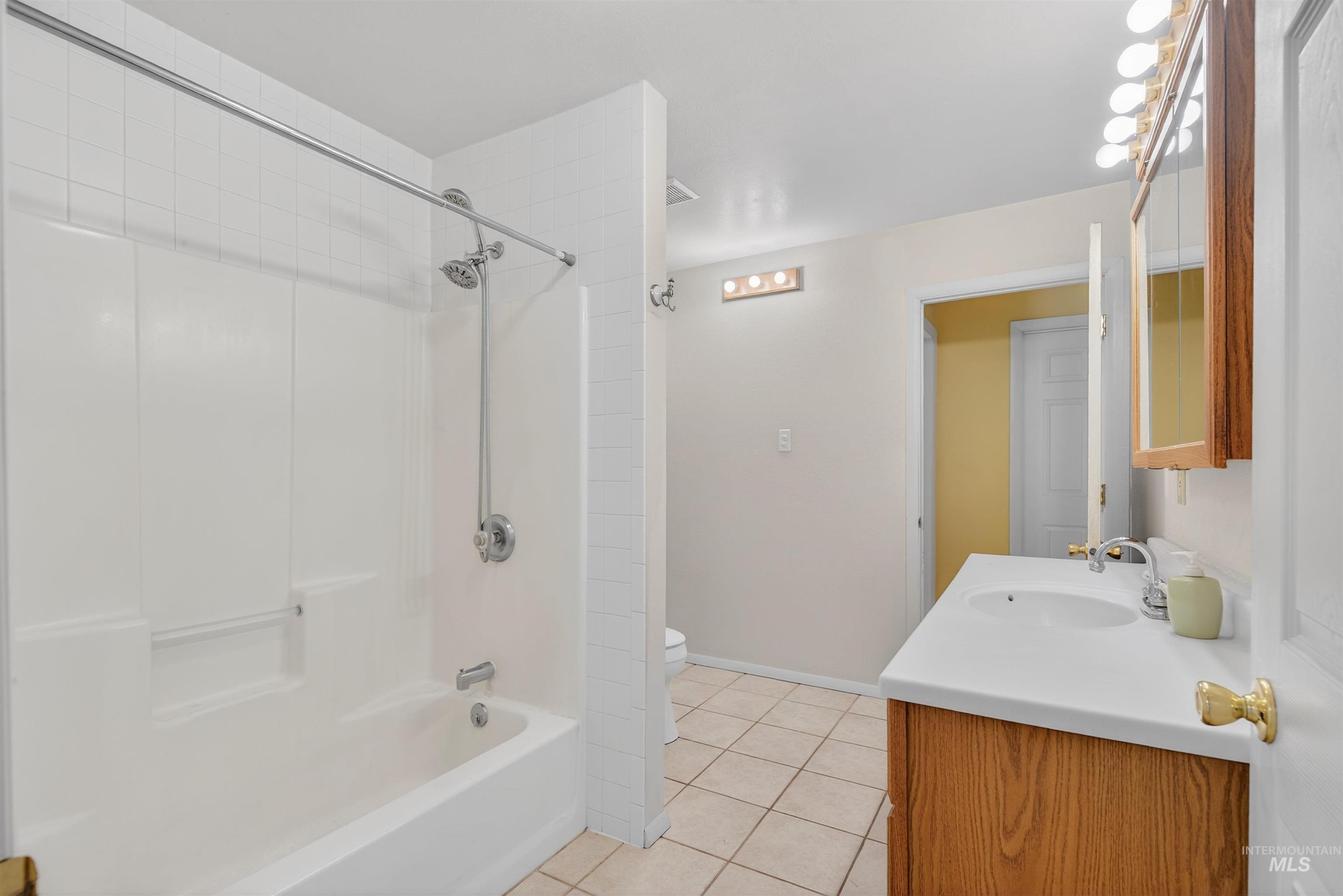 1585 Woodside Road Winchester, ID 83555 - Photo 14 of 47 Bathroom with vanity, tub / shower combination, and light tile patterned flooring