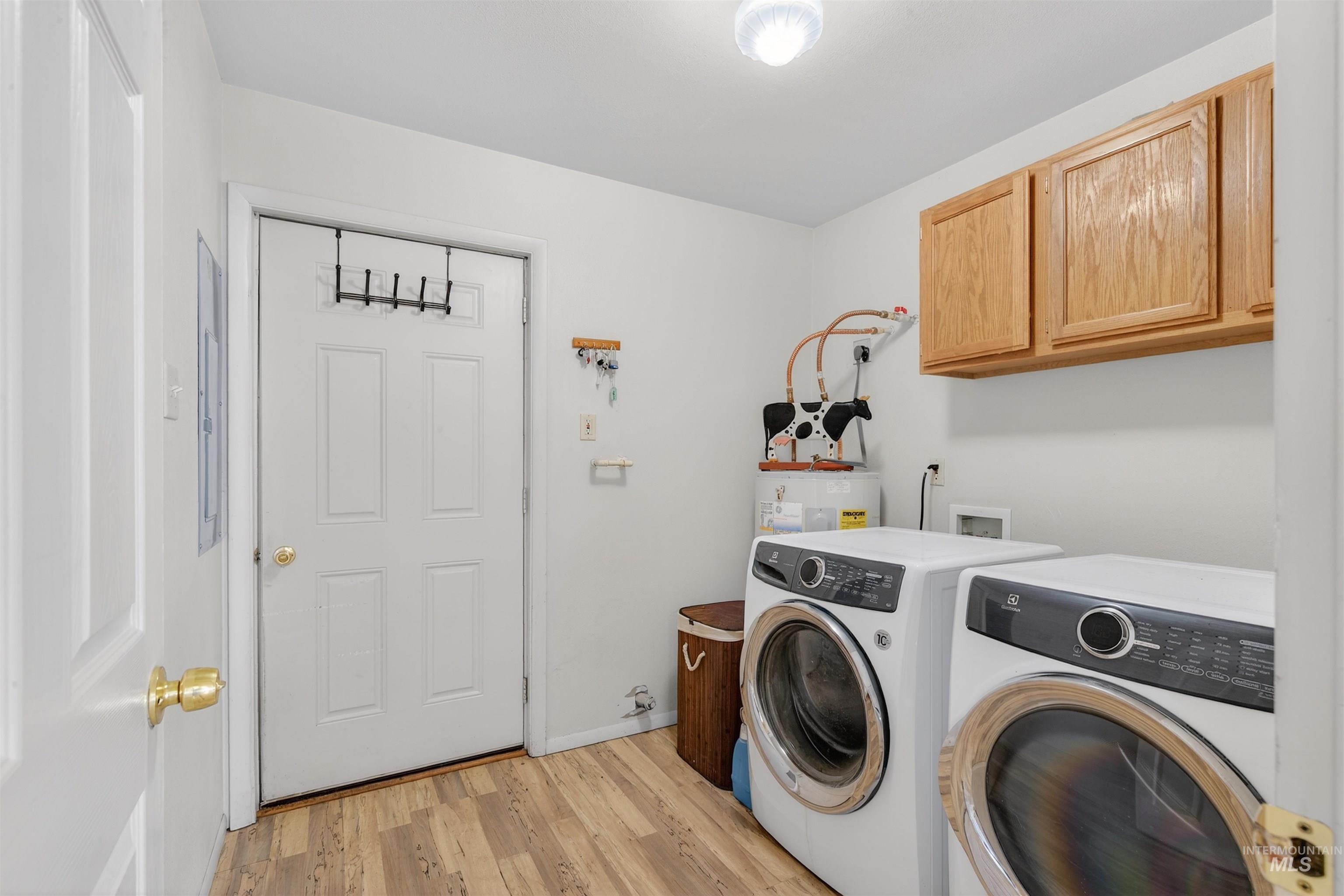 1585 Woodside Road Winchester, ID 83555 - Photo 17 of 47 Washroom with cabinet space, light wood-style flooring, and washer and dryer
