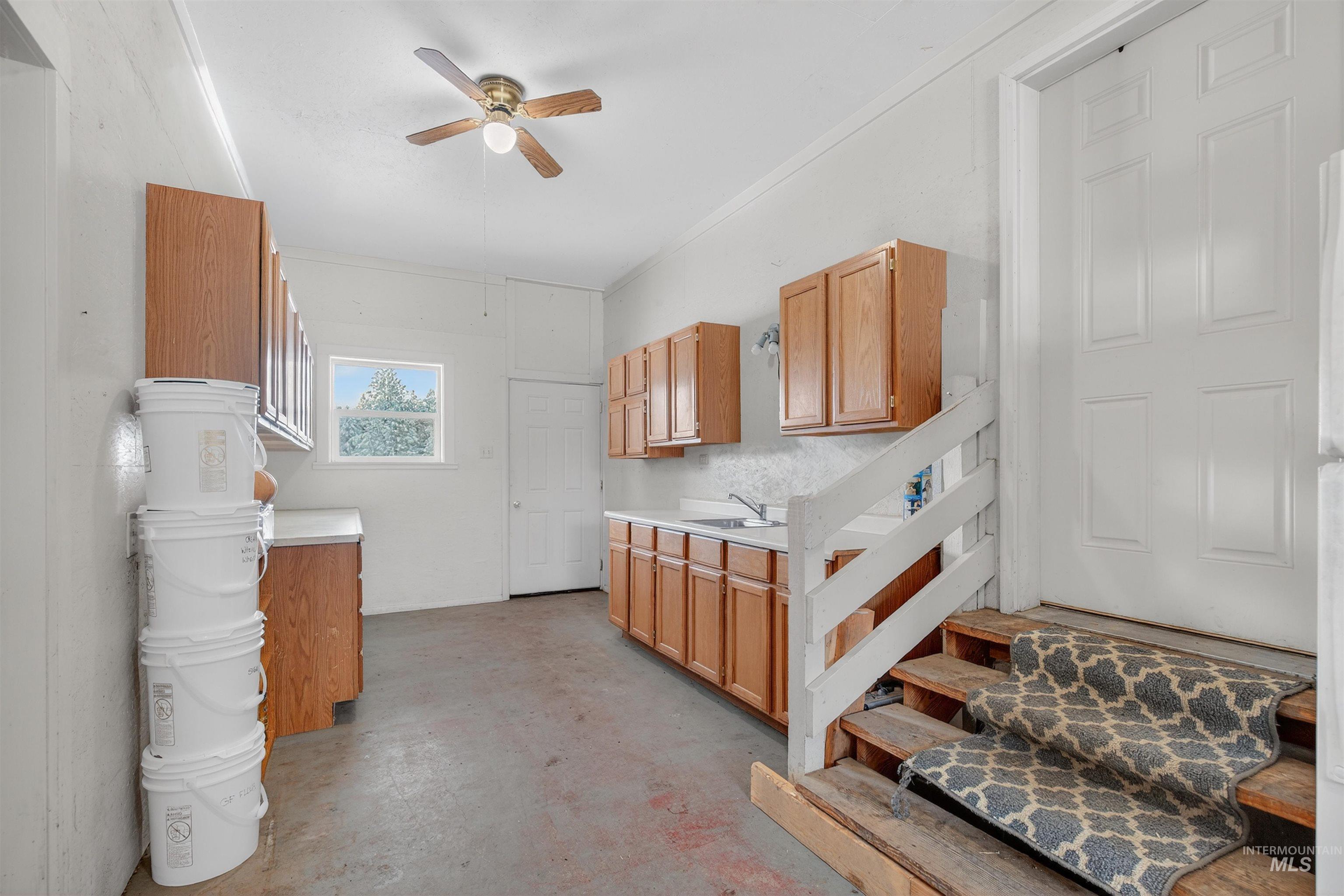 1585 Woodside Road Winchester, ID 83555 - Photo 23 of 47 Kitchen with light countertops, ornamental molding, concrete floors, and ceiling fan