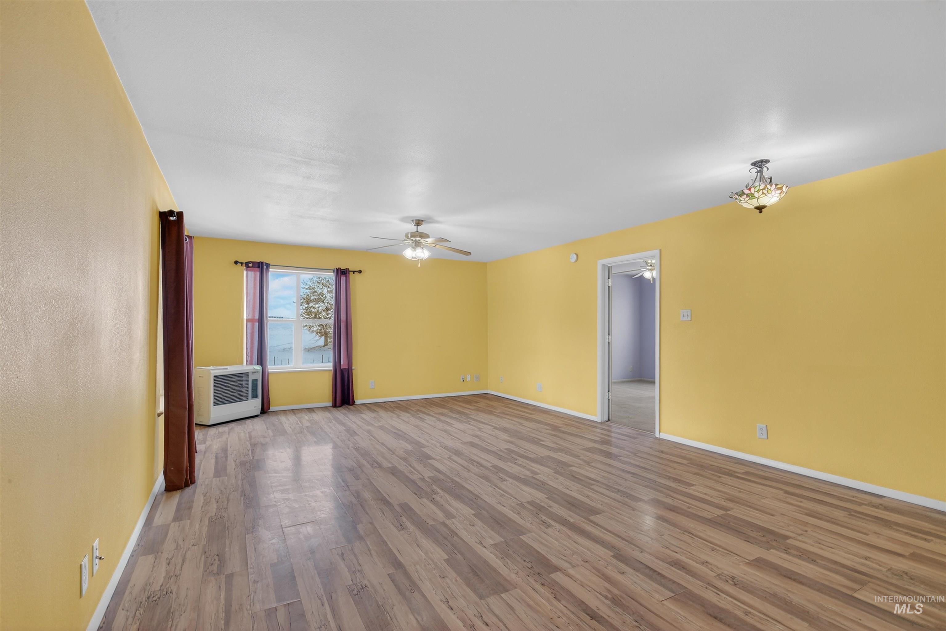 1585 Woodside Road Winchester, ID 83555 - Photo 6 of 47 Empty room featuring wood finished floors and ceiling fan