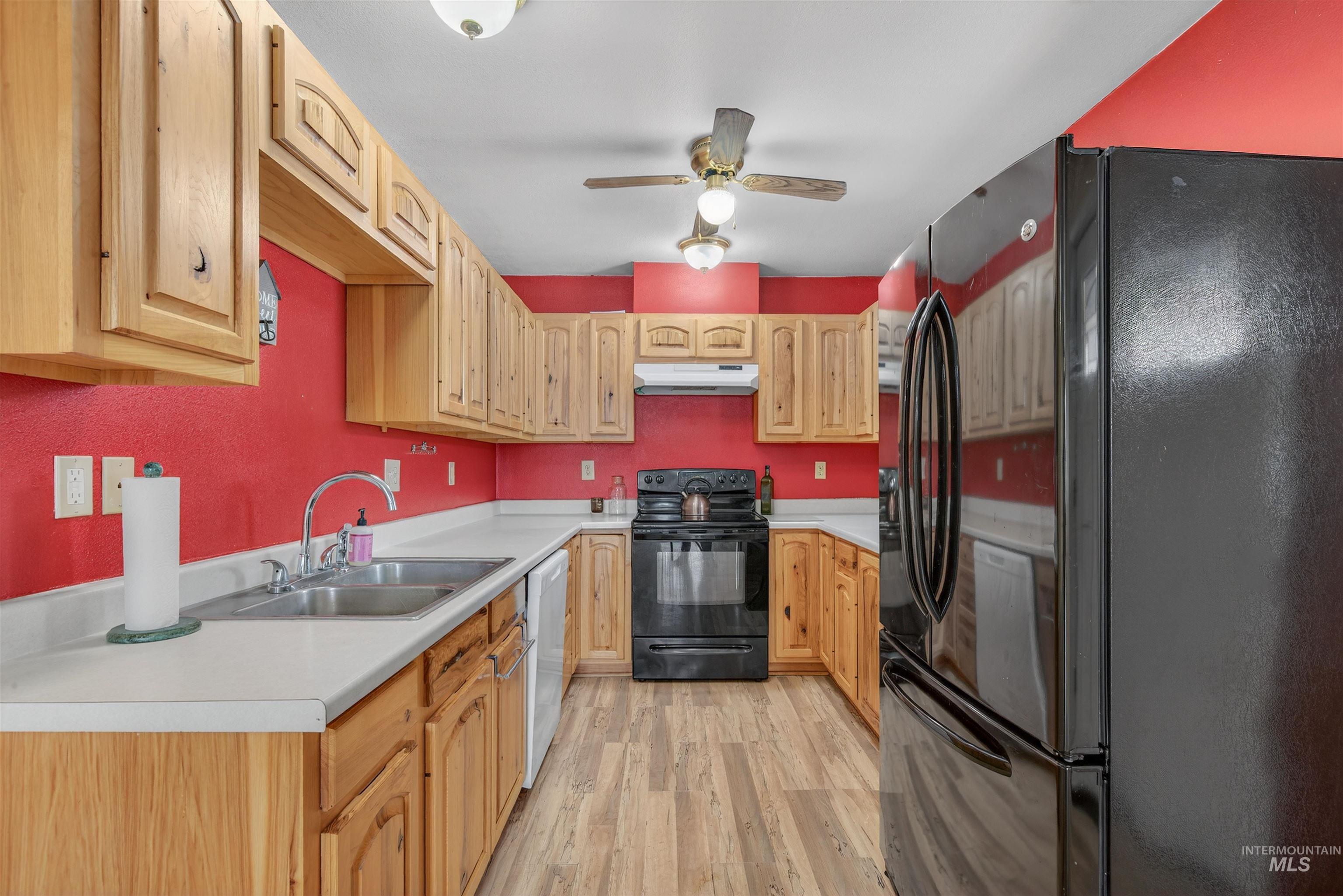 1585 Woodside Road Winchester, ID 83555 - Photo 9 of 47 Kitchen featuring black appliances, light countertops, light wood-style floors, and under cabinet range hood