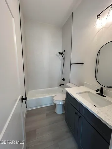 a bathroom with a granite countertop toilet sink and mirror