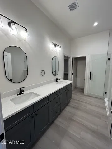 a bathroom with a double vanity sink and a mirror