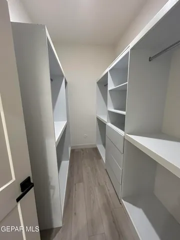 a view of walk in closet with empty racks