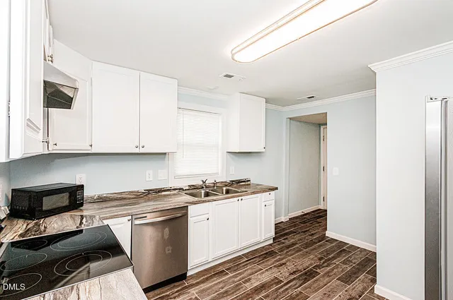 a kitchen with granite countertop a stove and a white cabinets
