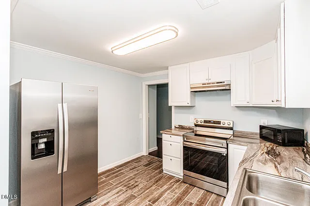 a kitchen with stainless steel appliances a refrigerator a stove a sink and dishwasher