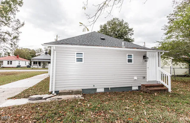 a view of a house with backyard and trees