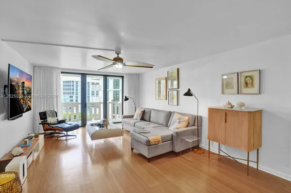 a living room with furniture floor to ceiling window and a flat screen tv