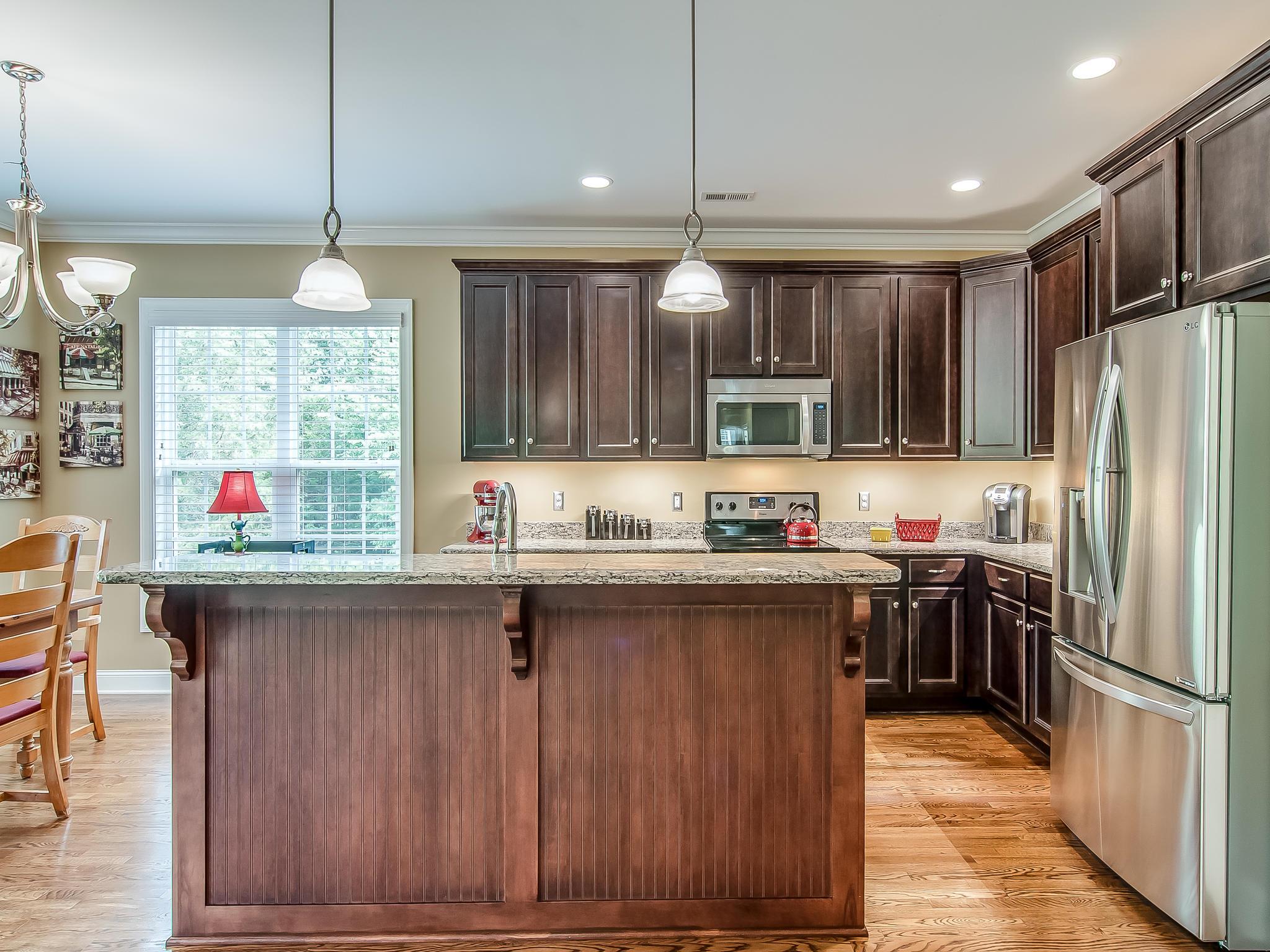2235 Harkreader Road Mount Juliet, TN 37122 - Photo 8 of 23 a kitchen with kitchen island granite countertop a stove a sink a center island and wooden cabinets