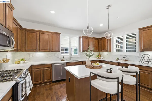 a kitchen that has a sink and chairs in it