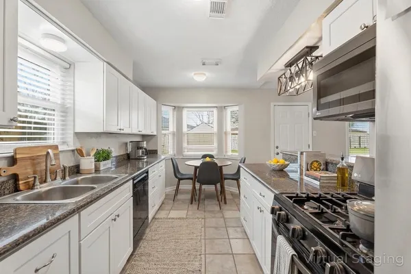 a kitchen with stainless steel appliances sink stove microwave and cabinets