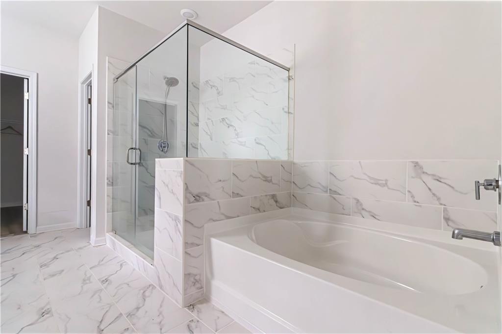 355 Chestnut Chase Hoschton, GA 30548 - Photo 13 of 22 a bathroom with a bathtub and a shower