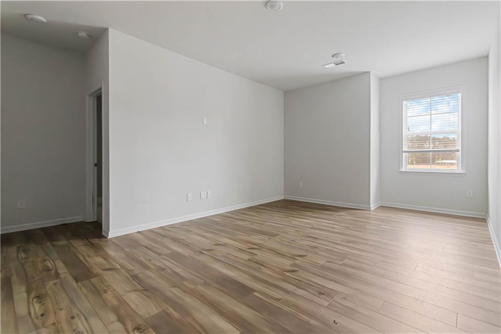 355 Chestnut Chase Hoschton, GA 30548 - Photo 14 of 22 a view of an empty room with wooden floor and a window