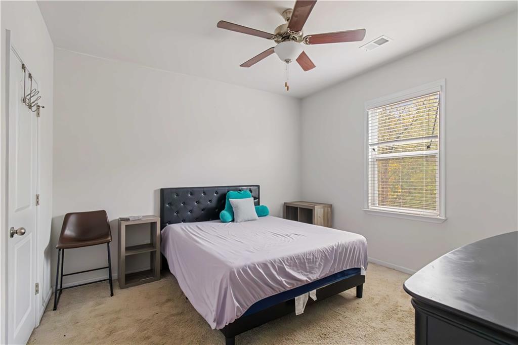 355 Chestnut Chase Hoschton, GA 30548 - Photo 16 of 22 a bedroom with a bed a desk and chair