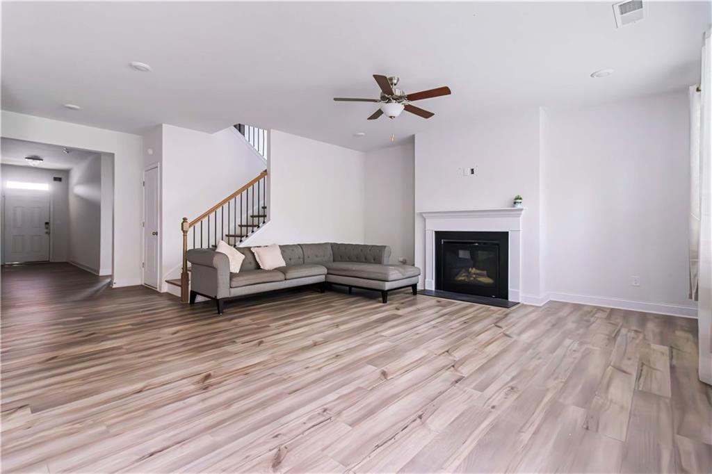 355 Chestnut Chase Hoschton, GA 30548 - Photo 3 of 22 a view of a livingroom with wooden floor a fireplace and windows