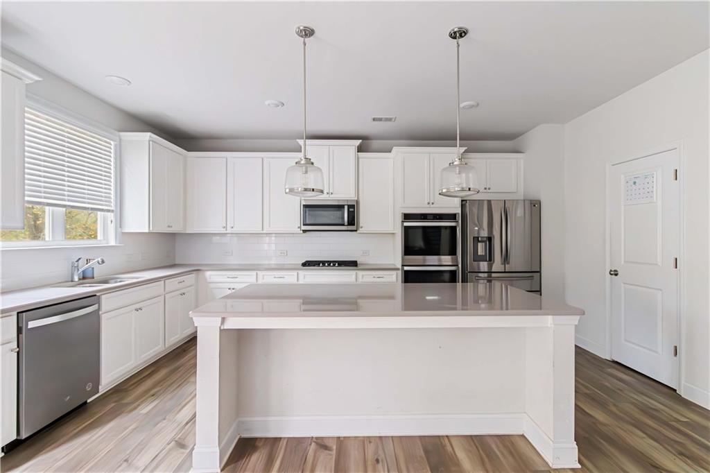 355 Chestnut Chase Hoschton, GA 30548 - Photo 6 of 22 a large kitchen with stainless steel appliances granite countertop a stove a sink and a refrigerator