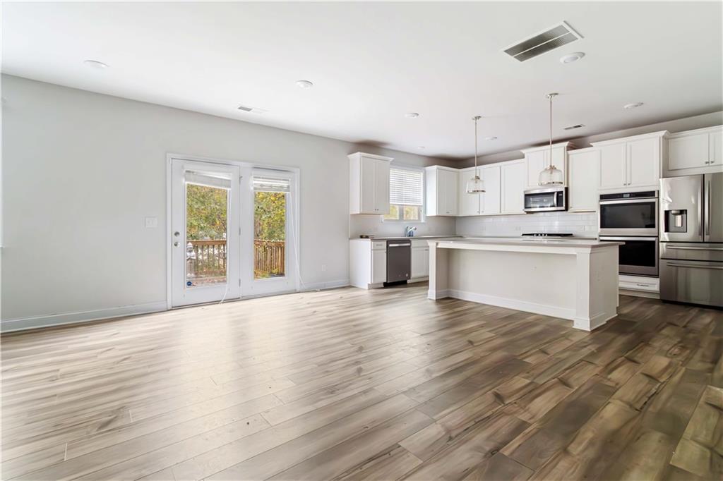 355 Chestnut Chase Hoschton, GA 30548 - Photo 7 of 22 a view of kitchen with wooden floor and electronic appliances