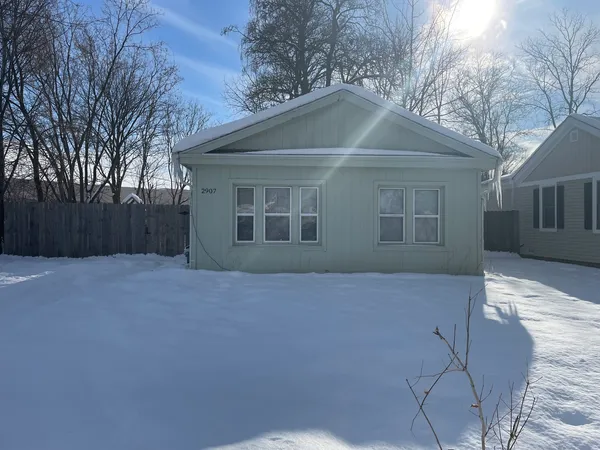 a front view of house with yard and trees around