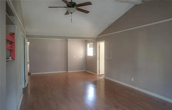a view of an empty room with wooden floor