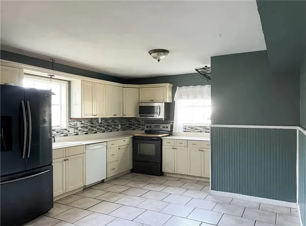 a kitchen with stainless steel appliances granite countertop a refrigerator and a stove top oven