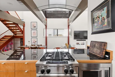 a large kitchen with stainless steel appliances granite countertop a stove and a sink