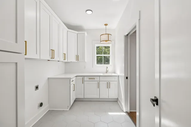 a kitchen with white cabinets and window