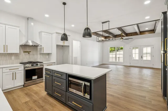 a kitchen with stainless steel appliances granite countertop a stove a sink and a refrigerator