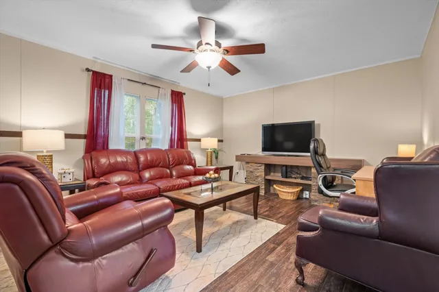 a living room with furniture a ceiling fan and a window