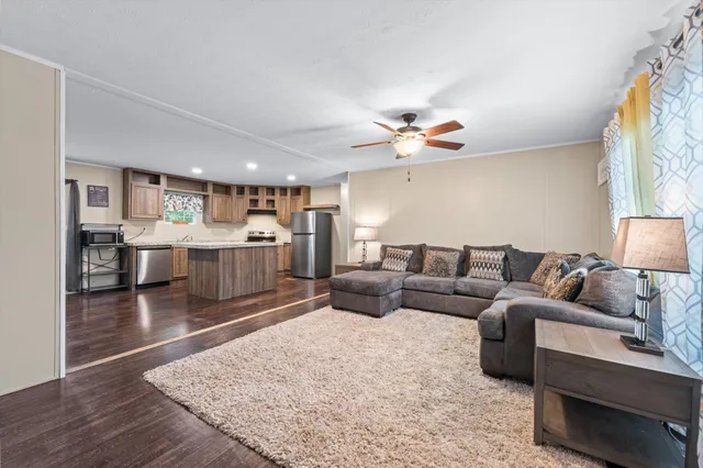 a living room with furniture and kitchen view