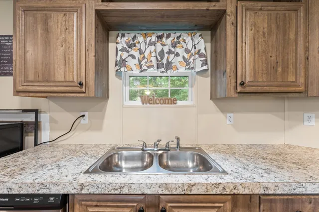 a kitchen with granite countertop a sink and a stove