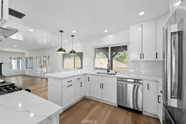 a kitchen with granite countertop stainless steel appliances a stove a sink a center island and cabinets