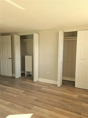 an empty room with wooden floor and closet