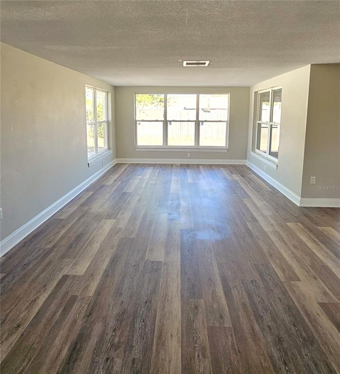 7821 Lotus Drive Port Richey, FL 34668 - Photo 4 of 19 wooden floor in an empty room with a window
