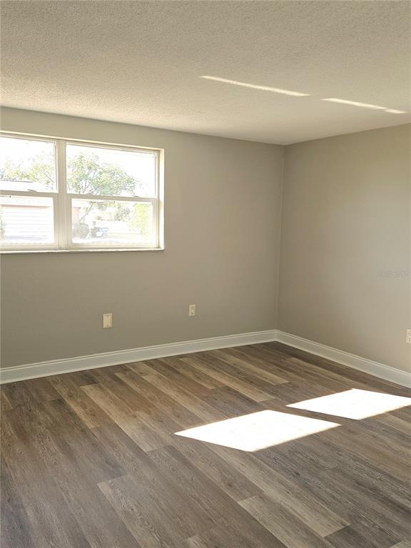 7821 Lotus Drive Port Richey, FL 34668 - Photo 5 of 19 an empty room with wooden floor and windows