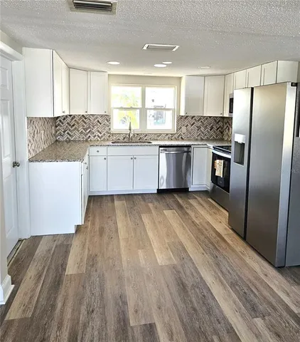 a kitchen with stainless steel appliances a refrigerator sink and cabinets