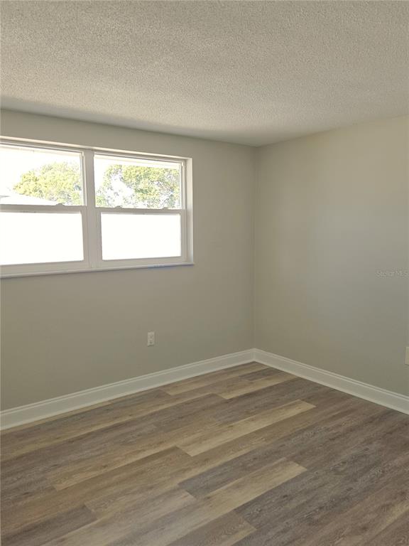 7821 Lotus Drive Port Richey, FL 34668 - Photo 10 of 19 a view of an empty room with wooden floor and a window