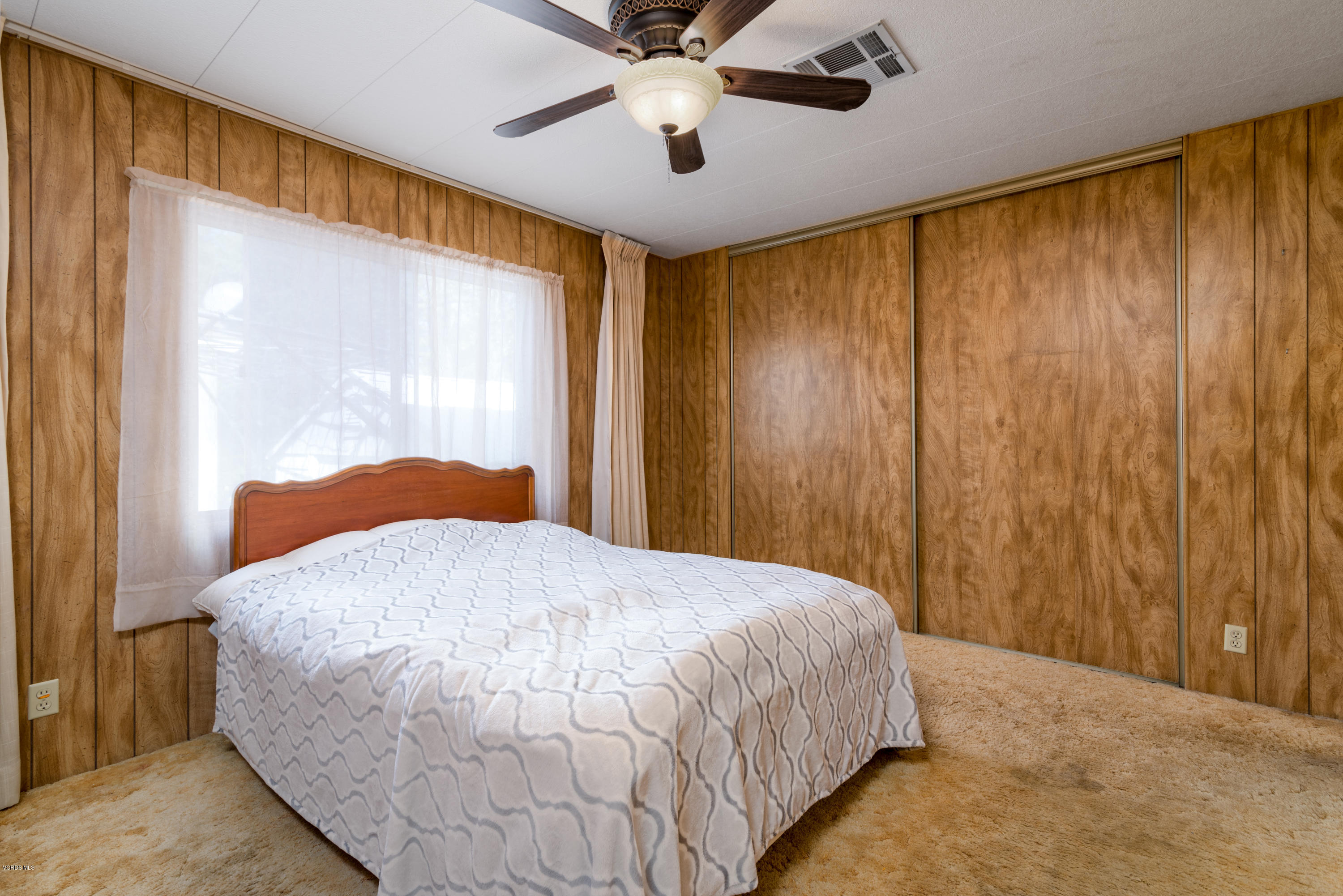 6480 Katherine Street, Unit 16 Simi Valley, CA 93063 - Photo 15 of 24 a bedroom with a bed and a chandelier