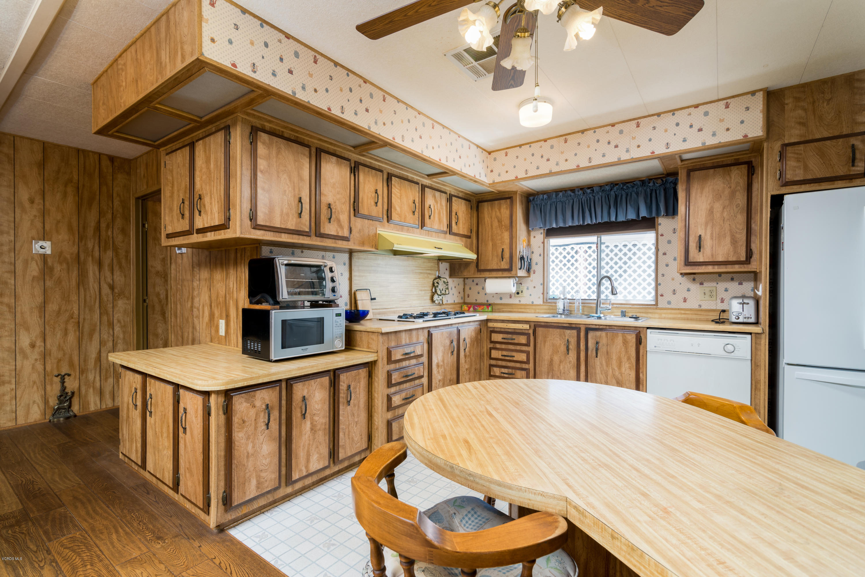 6480 Katherine Street, Unit 16 Simi Valley, CA 93063 - Photo 3 of 24 a kitchen with stainless steel appliances kitchen island granite countertop a table chairs in it and a microwave