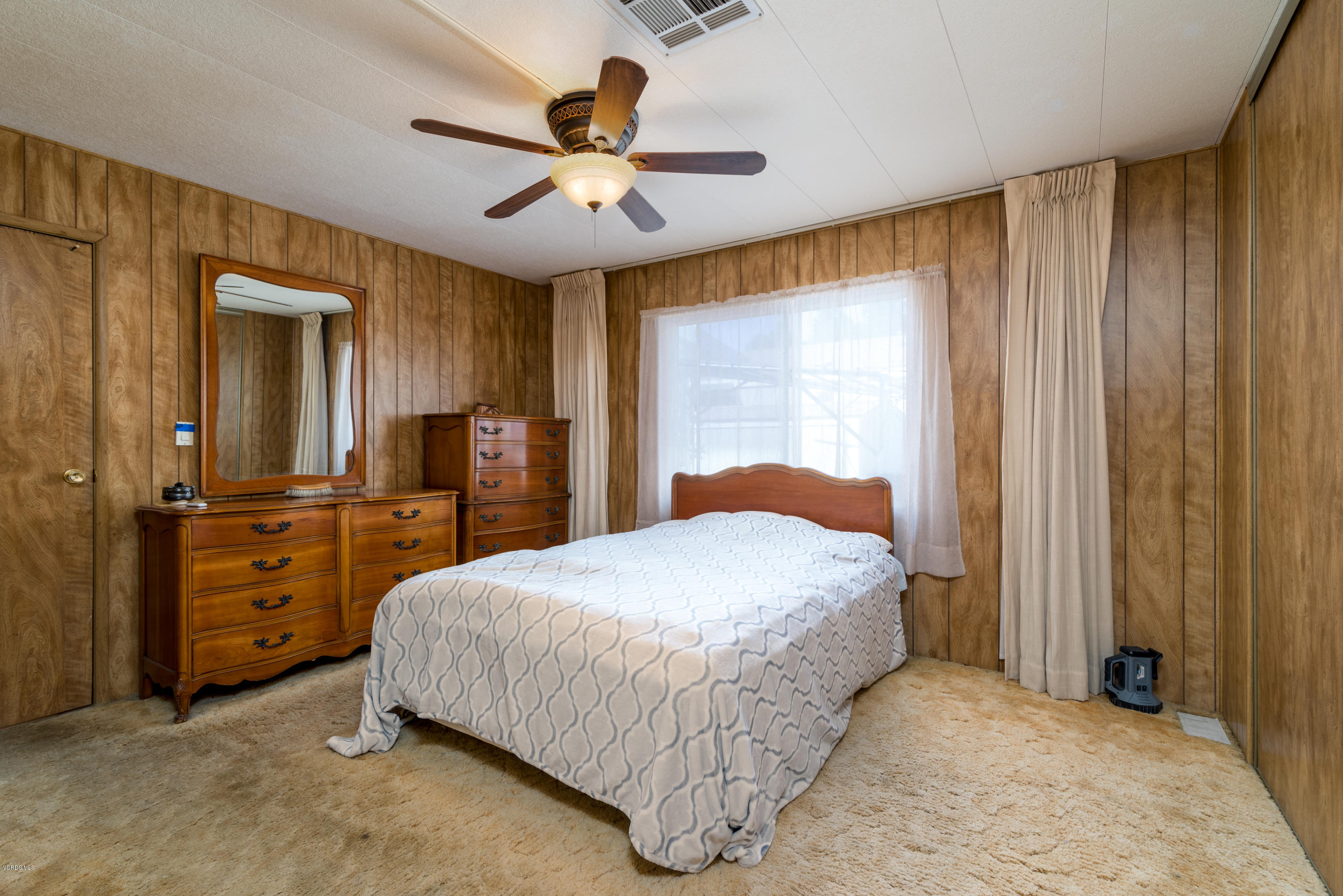 6480 Katherine Street, Unit 16 Simi Valley, CA 93063 - Photo 5 of 24 a bedroom with a bed and a chandelier