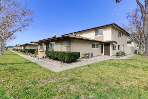 a front view of a house with yard patio and green space