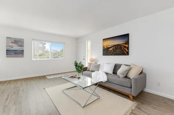 a living room with furniture and a painting on the wall