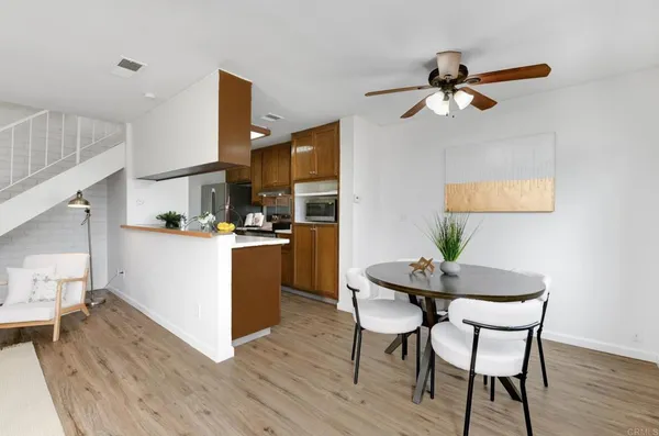 a kitchen with a dining table chairs and white cabinets